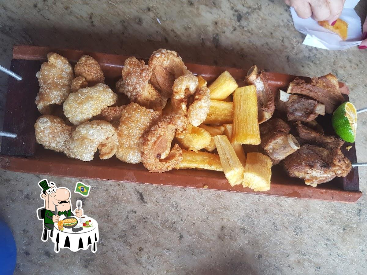 Tábua de petiscos com mandioca e carnes servida no restaurante.