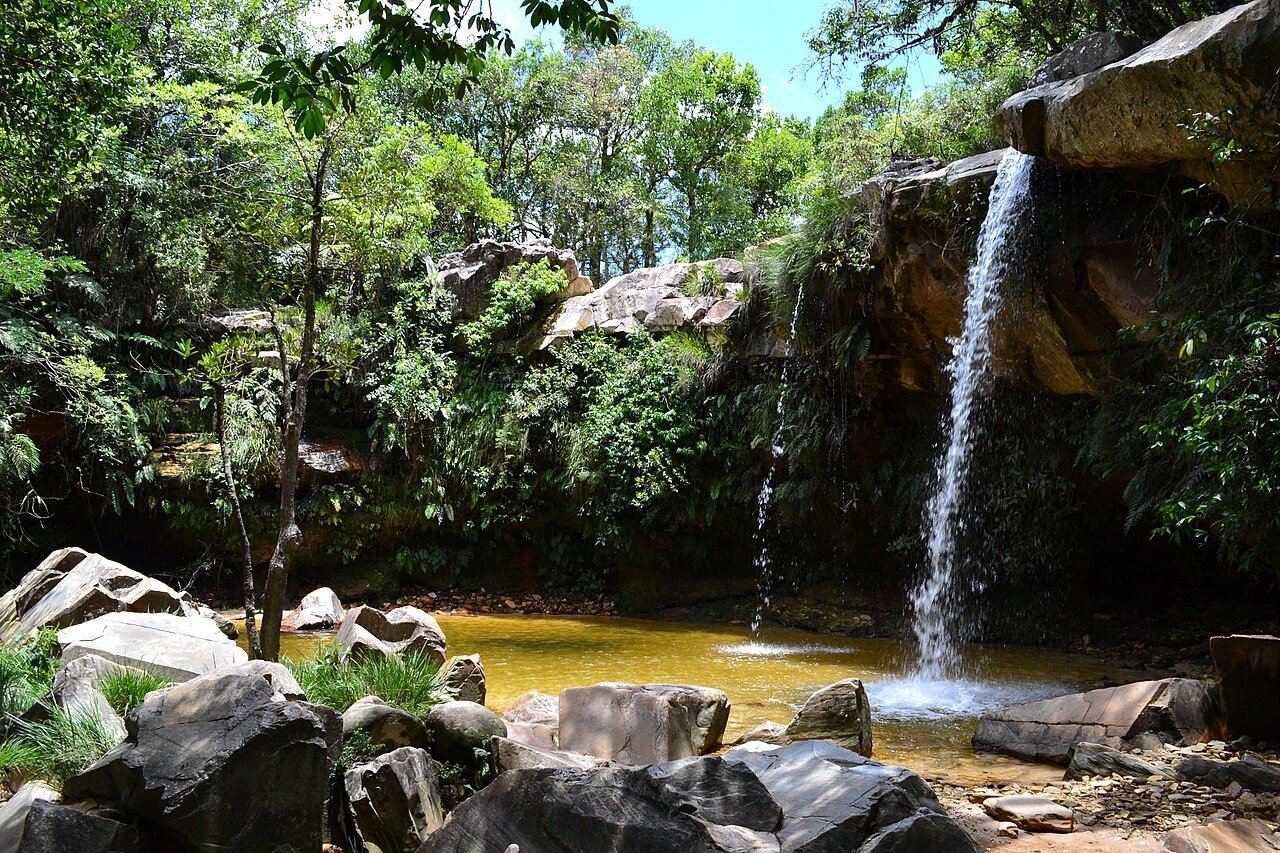 Cachoeira das Borboletas, em São Thomé das Letras: queda d’água, poço, pedras e mata em um enquadramento amplo.